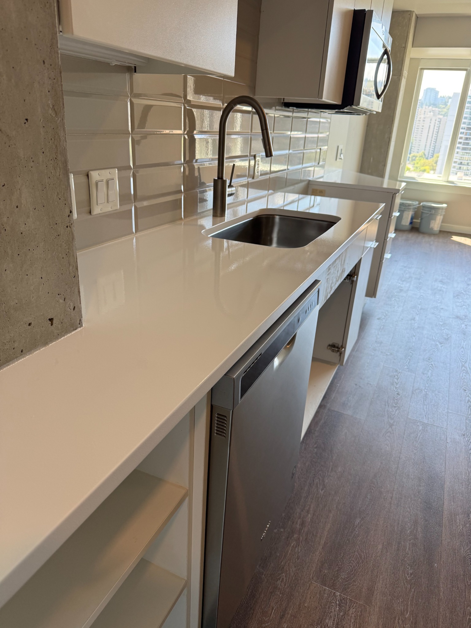 Glossy pure white countertop beside a stainless steel sink in a KPX project